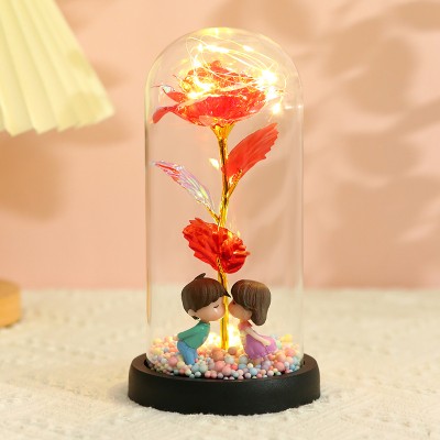 وردة اصطناعية مطلية بالذهب لعيد الحب، بقاعدة خشبية مبتكرة وقبة زجاجية، مزينة بتماثيل زوجين وكرات إسفنجية متعددة الألوان، معبأة في علبة هدايا مثالية لهدايا عيد الحب